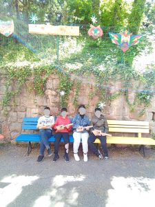 alunni seduti su panchina nel giardino winkler con in mano gli strumenti costruiti durante il laboratorio