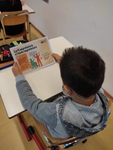 bambino di spalle con materiale della cooperativa