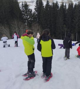 ragazzi con le ciaspole camminano nella neve