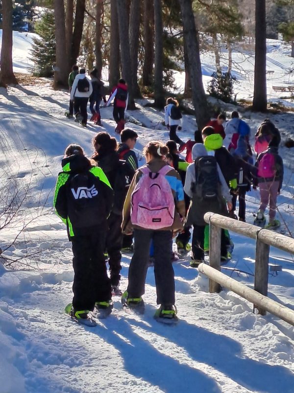 ragazzi con le ciaspole camminano nella neve