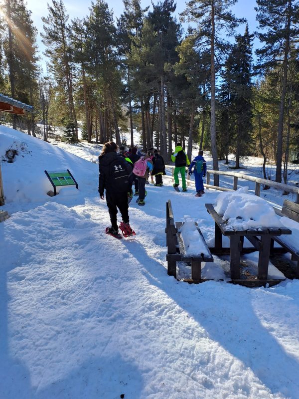 ragazzi con le ciaspole camminano nella neve