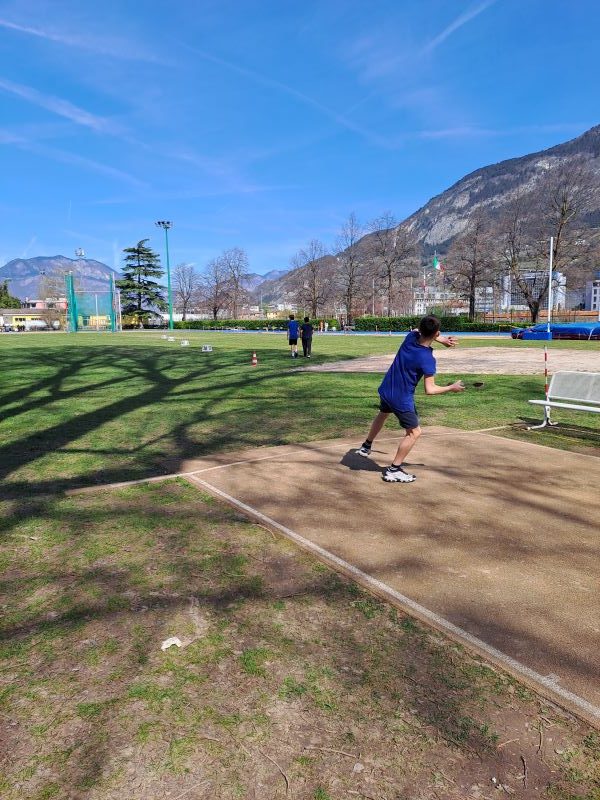 ragazzo di spalle lancia vortex nel campo di atletica