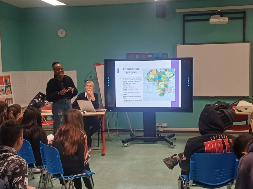 fotografia che rappresenta Better, una ragazza africana, che parla alle classi riunite in aula magna