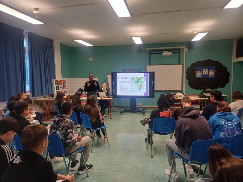 fotografia che rappresenta Better, una ragazza africana, che parla alle classi riunite in aula magna