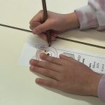 le mani di una bambina che colorano il segnalibro ad orsetto