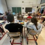 bambini che leggono seduti in classe