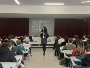 Foto: autrice parla ai ragazzi di spalle in un un'aula magna