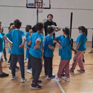 BAMBINI DI SPALLE CON MAGLIETTE AZZURRE GIOCANO NELLA PALESTRA DI GARDOLO