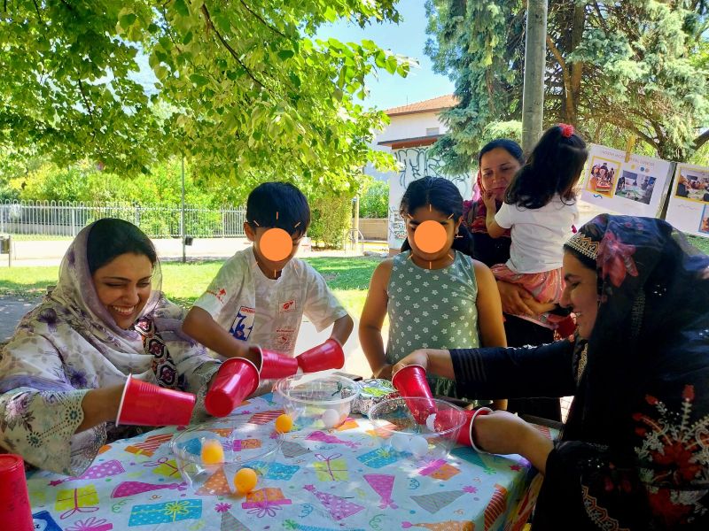 foto: due mamme e bambini si sfidano in un gioco con palline colorate