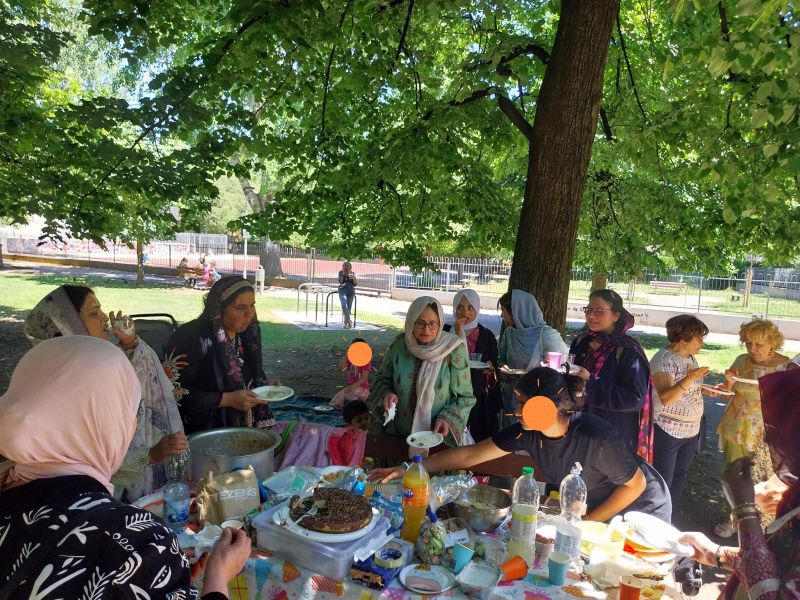 foto: donne partecipanti alla festa, alcune con costumi tradizionali del mondo, condividono cibi e bevande